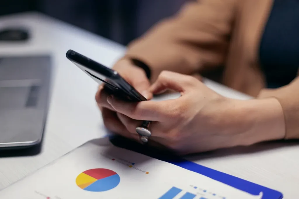 person on phone with graph on table