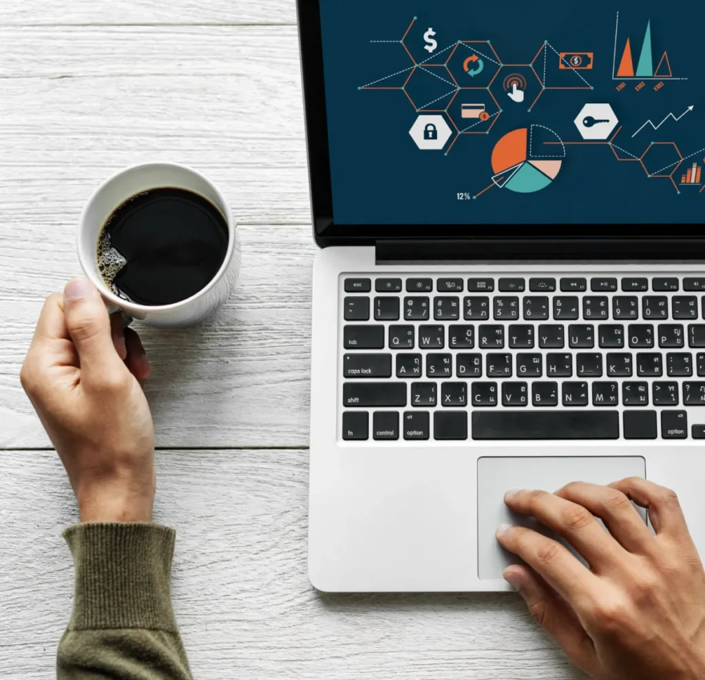 marketing strategy on laptop with coffee on desk and in hand
