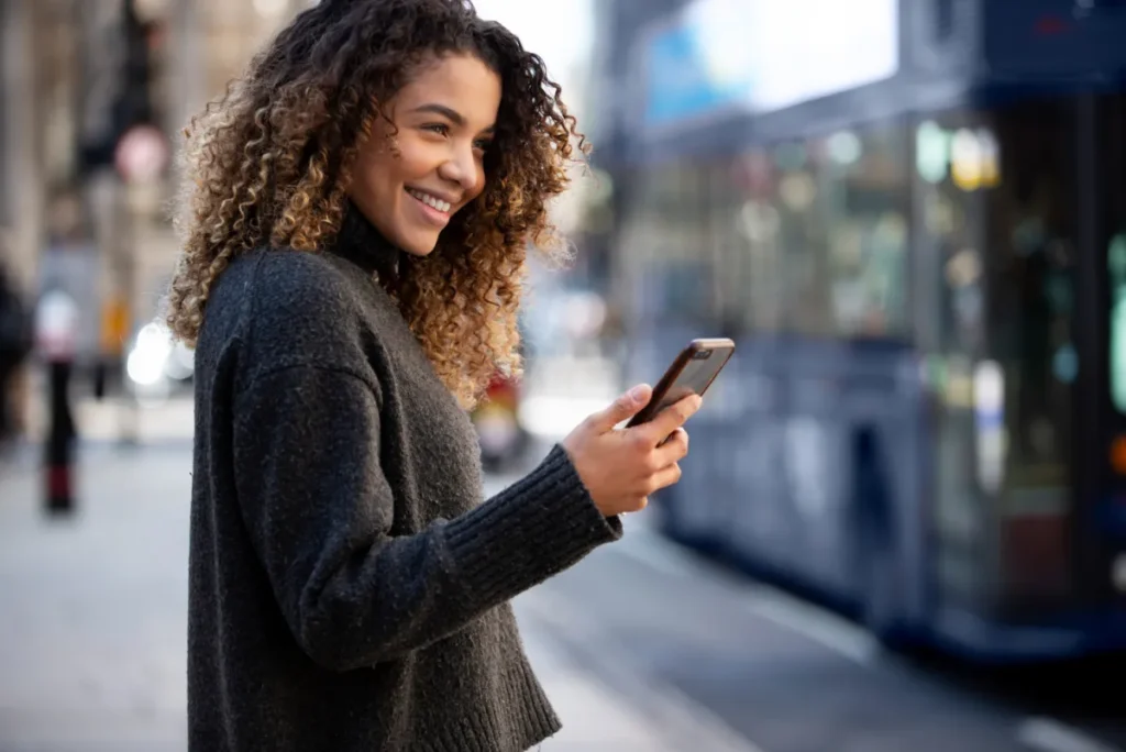 girl on phone blurred out bus in background